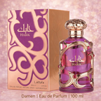 Lattafa „Habik“ Damen Eau de Parfum (100 ml) mit violettem Glasflakon und goldener Ornamentverzierung, neben passender lila-goldener Verpackung, vor rosafarbenem, schimmerndem Hintergrund.