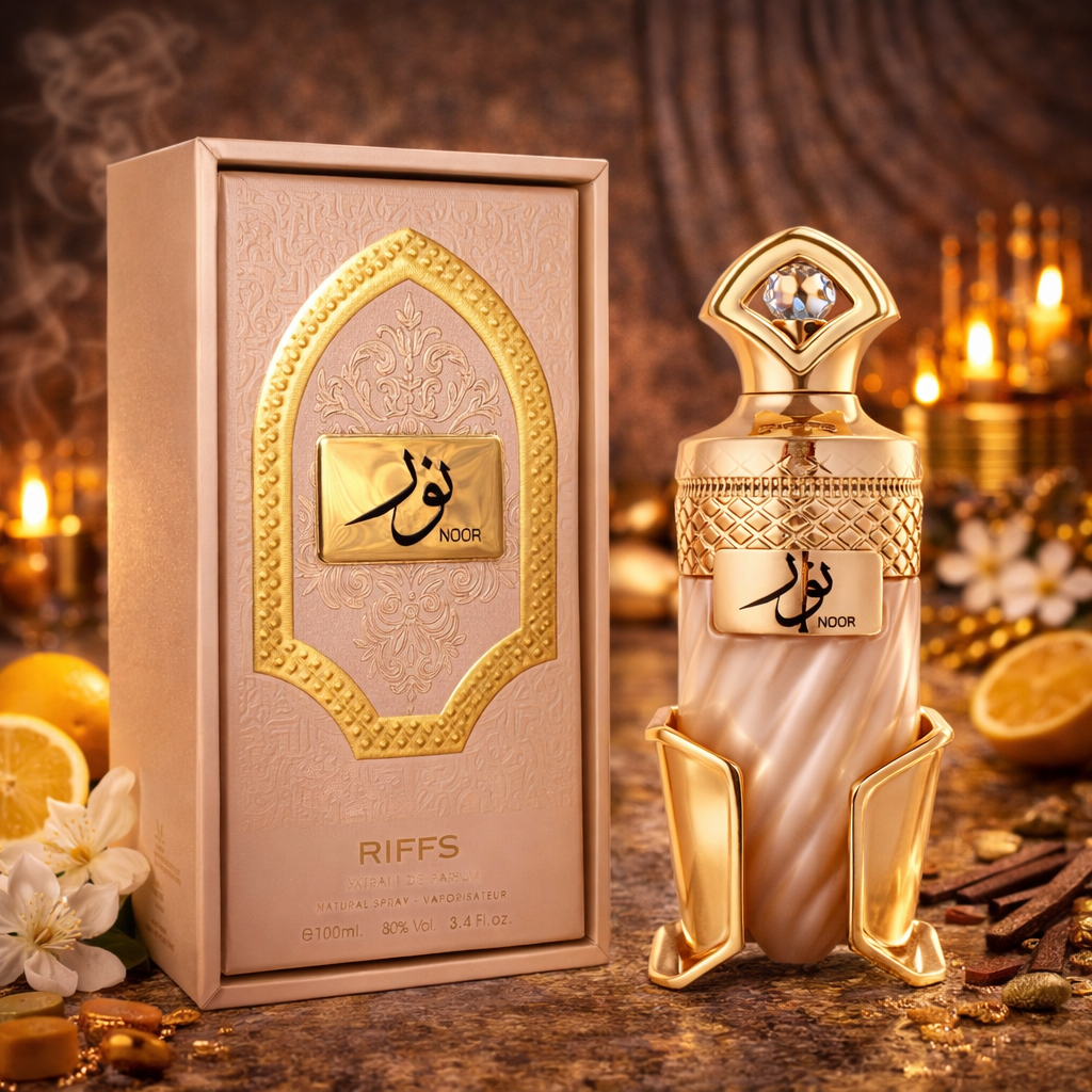 Edles Riiffs Parfum „Noor“ (100 ml) mit goldverziertem, orientalisch gestaltetem Flakon und passender roséfarbener Verpackung. Der luxuriöse Flakon mit arabischer Schrift und goldenen Ornamenten steht neben der dekorativen Box in stimmungsvollem Ambiente mit Kerzenlicht, Gewürzen und Zitrusfrüchten, was den warmen, sinnlichen Charakter des Duftes unterstreicht.